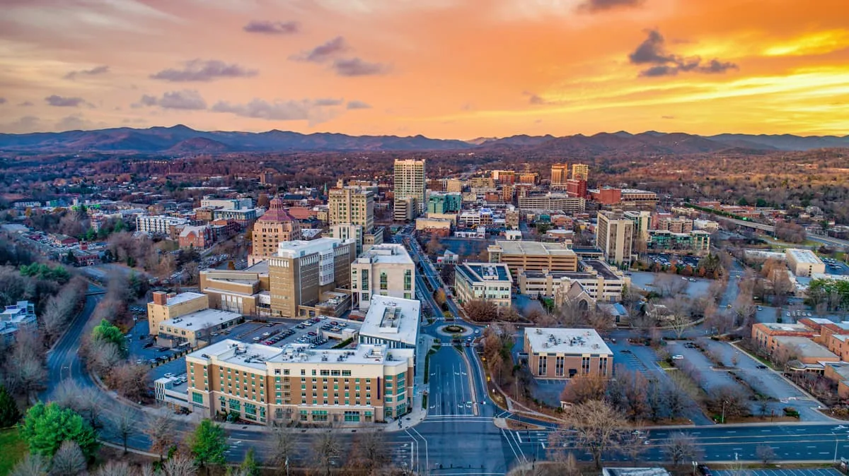 Downtown Asheville at sunset, the Blue Ridge Mountains on the horizon